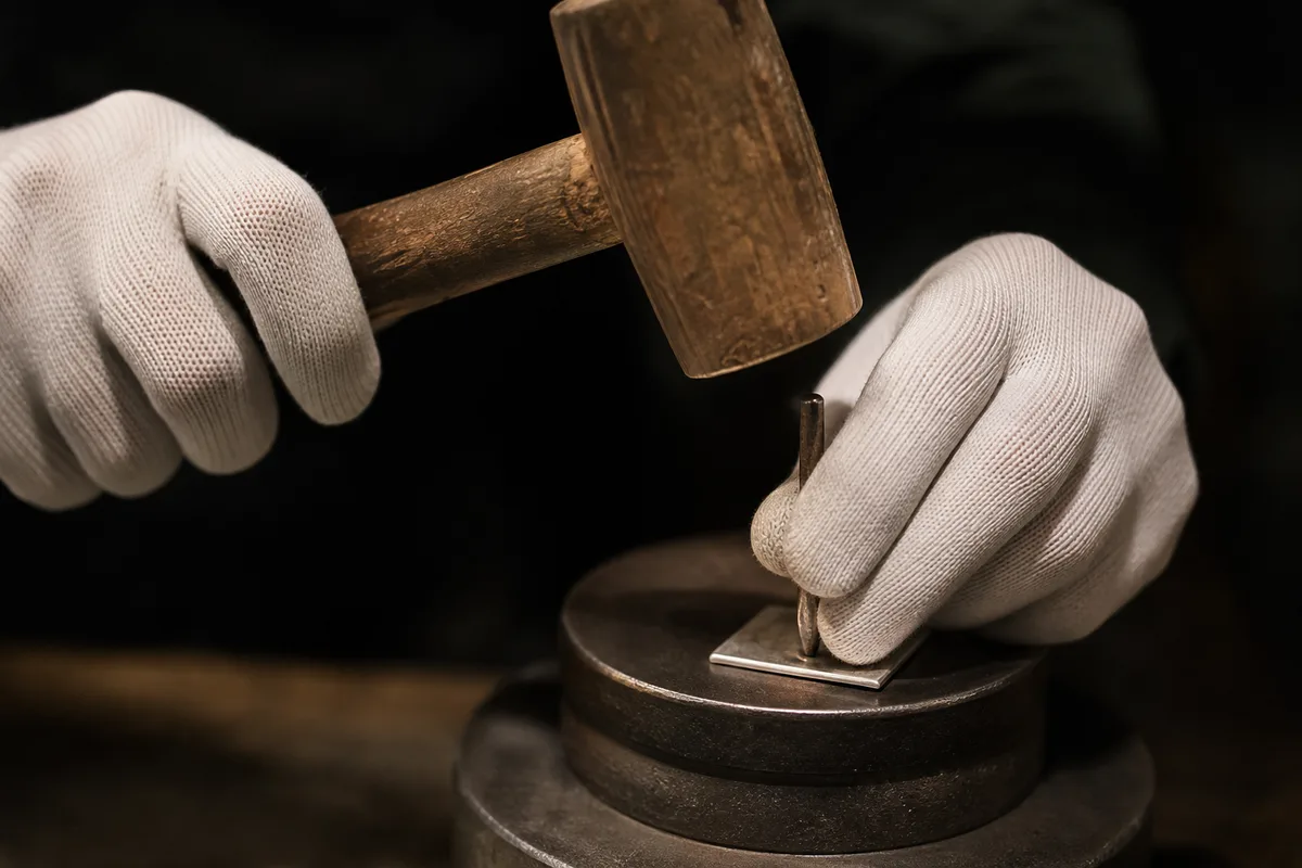 Établi de bijoutier en lumière naturelle avec bagues en argent en cours de finition